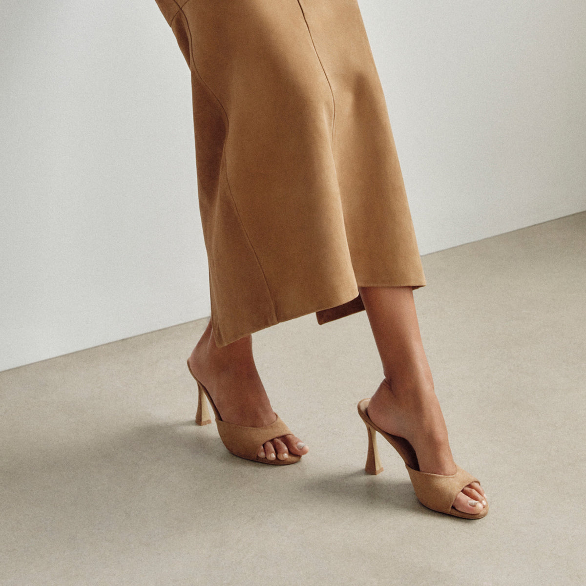 a woman's legs in a skirt and heels