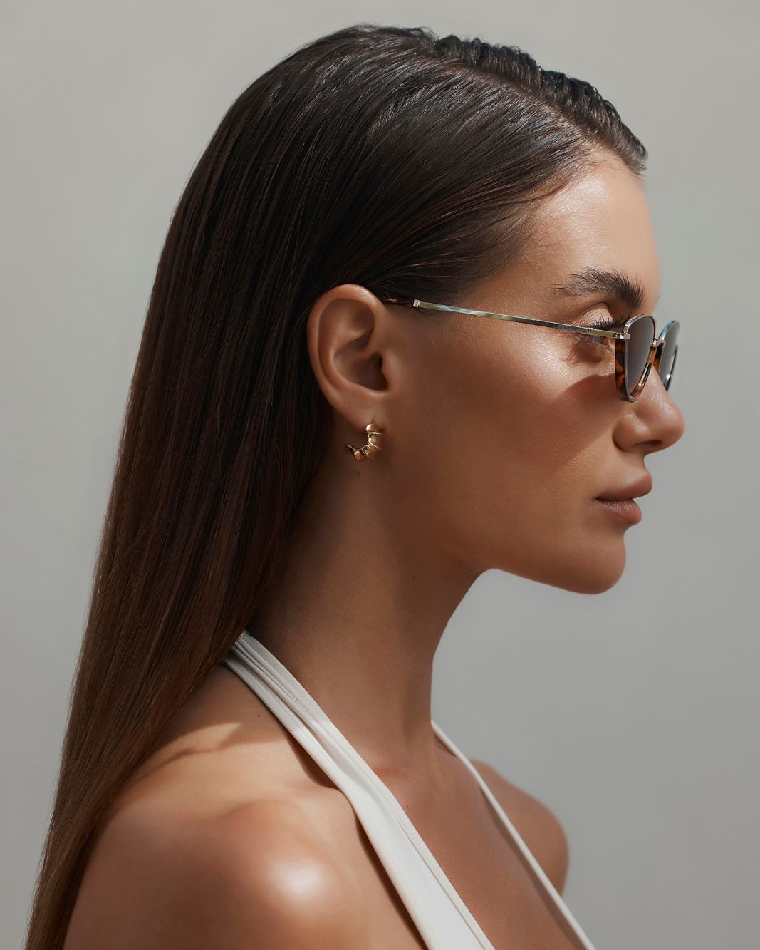 a woman wearing sunglasses and a white top