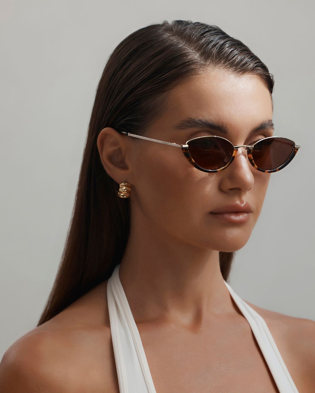 a woman wearing sunglasses and a white top