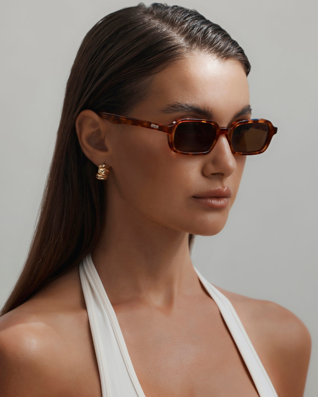 a woman wearing sunglasses and a white top