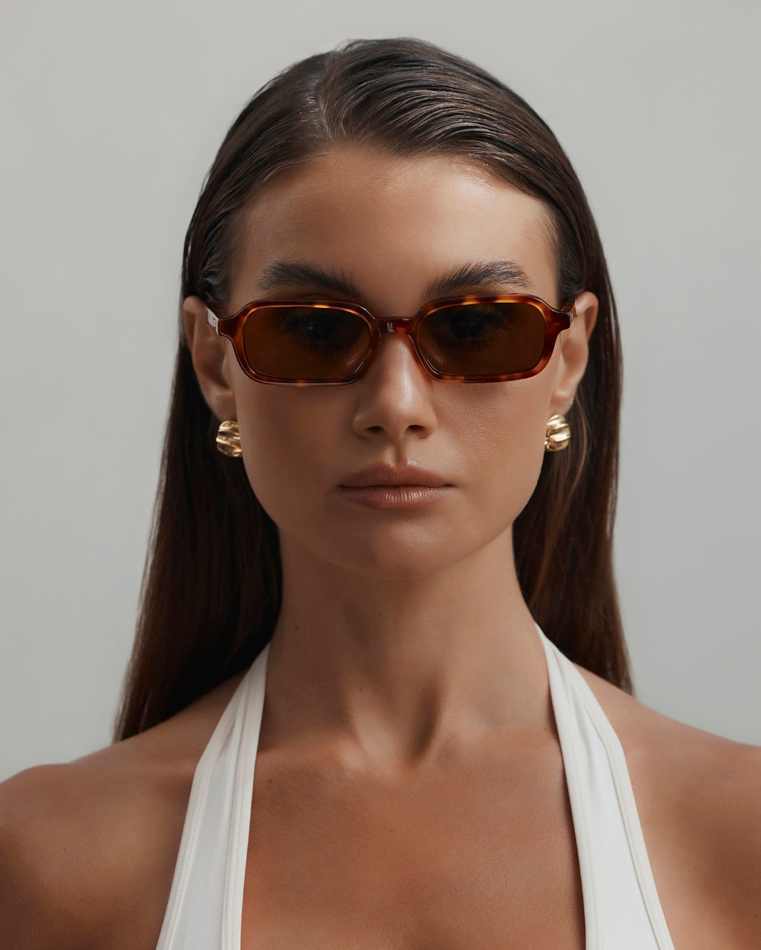 a woman wearing sunglasses and a white top