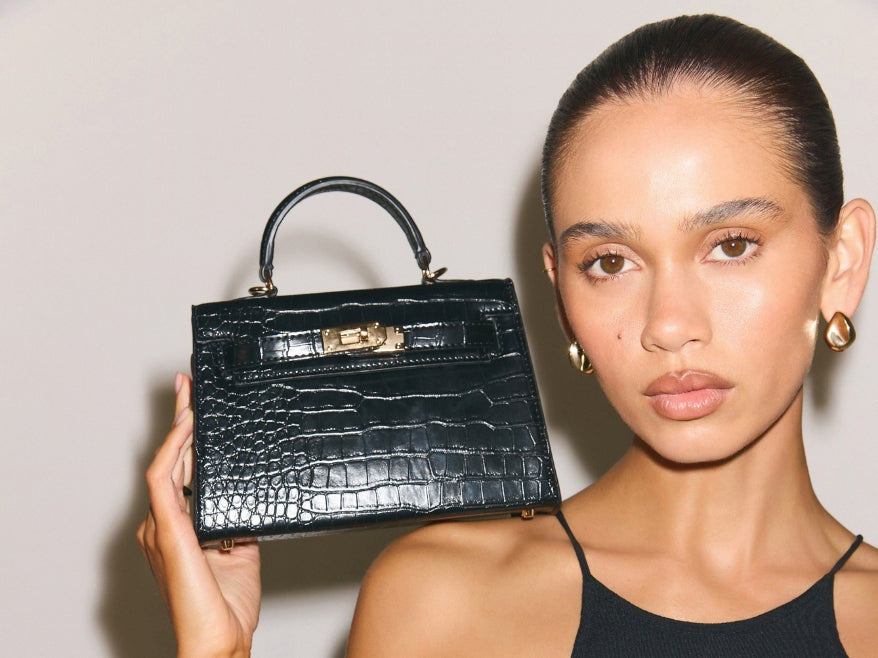 a woman holding a black purse