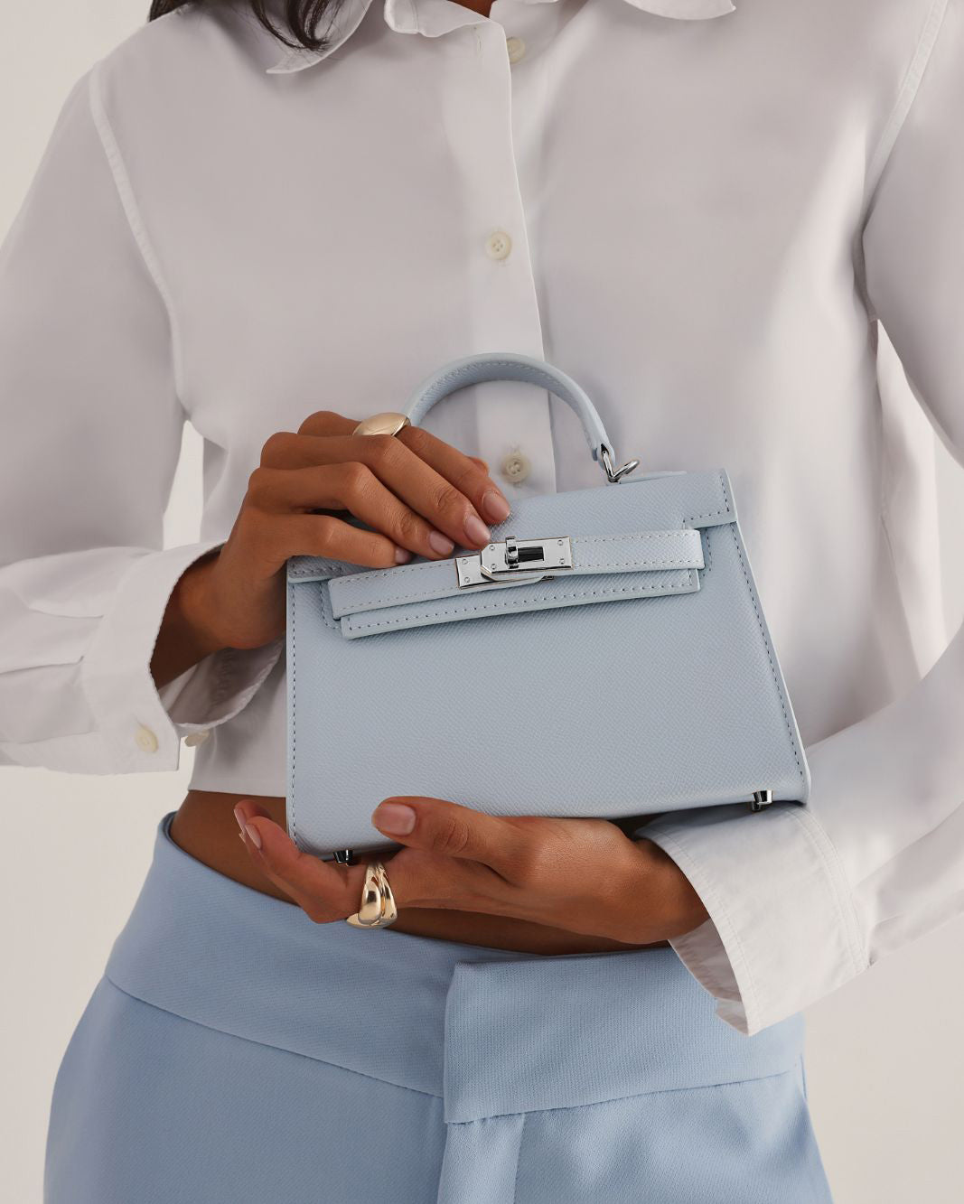 a woman holding a small blue bag